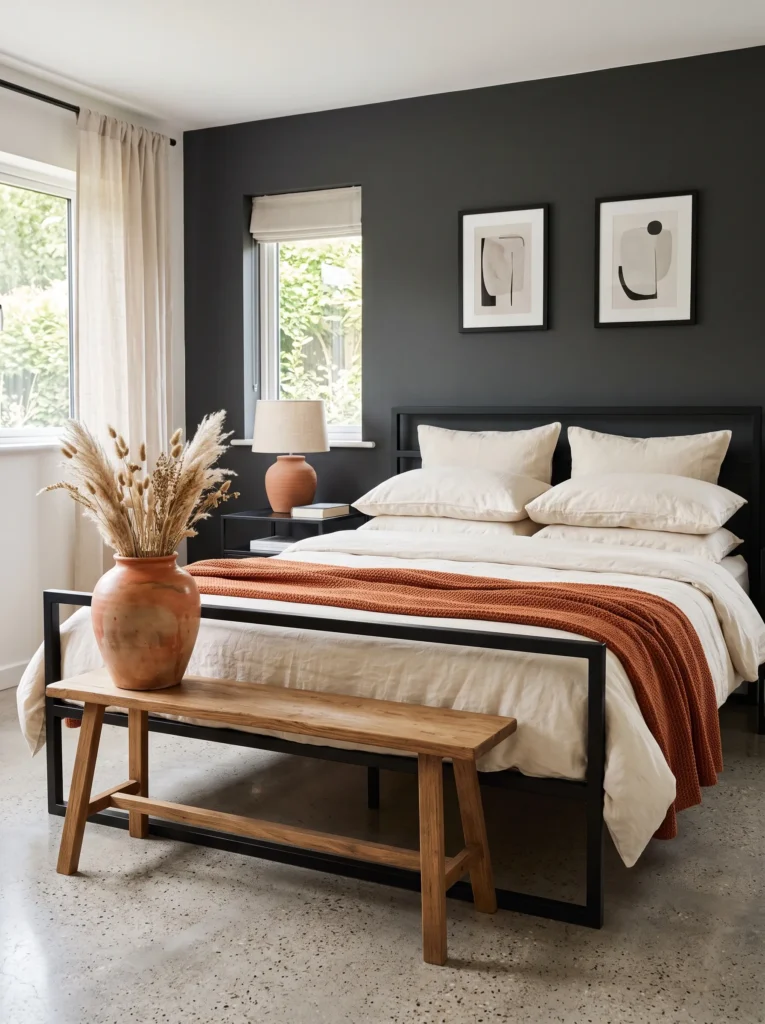 Charcoal bedroom wall with a terracotta vase and dried botanicals