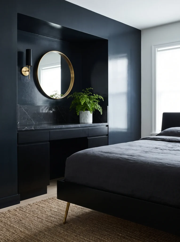 Built-in marble-look vanity nook against a cool-toned black wall with a round mirror