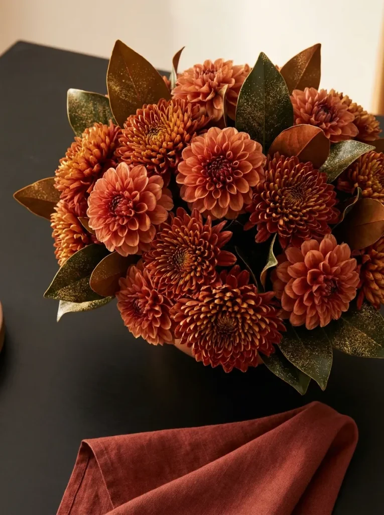 Oversized gold-rimmed cranberry glass bowl with visible cranberries and magnolia leaves