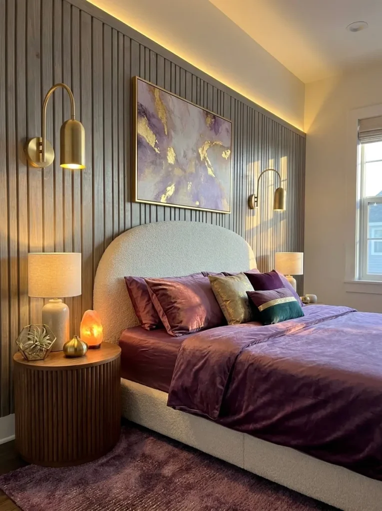 Fluted gray-washed paneling behind a cream boucle bed with foxglove-violet bedding